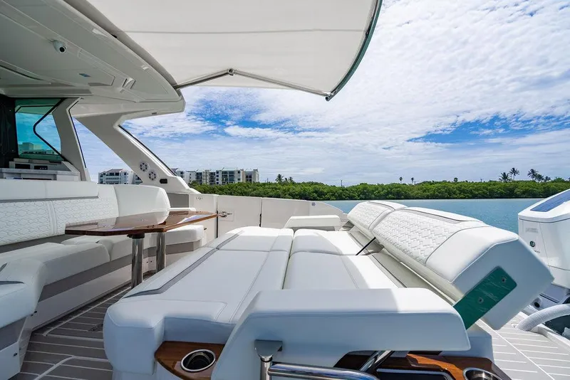 Slide: The Image of Luxurious 2025 Tiara Yachts 48 LS with elegant seating and scenic waterfront view. - 13