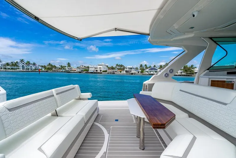 Slide: The Image of Luxurious 2025 Tiara Yachts 48 LS with elegant seating, overlooking serene waterfront homes. - 16