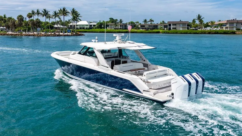 Slide: The Image of 2025 Tiara Yachts 48 LS cruising on clear blue water near a tropical shoreline. - 4