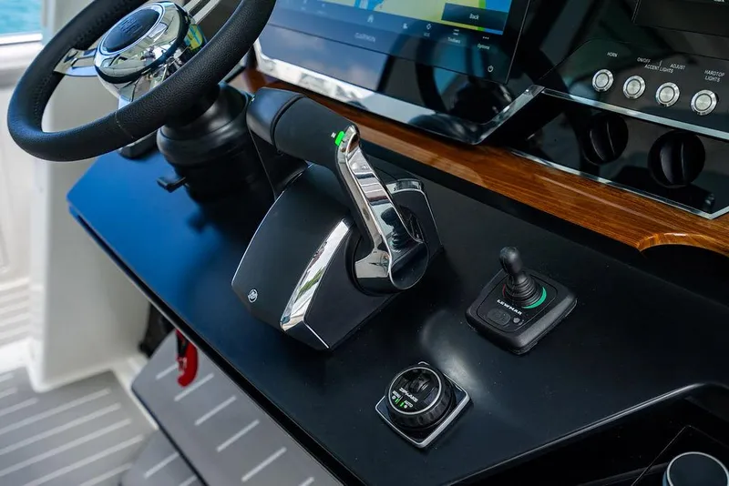 Slide: The Image of Control panel of 2025 Tiara Yachts 48 LS, featuring steering wheel and joystick. - 40