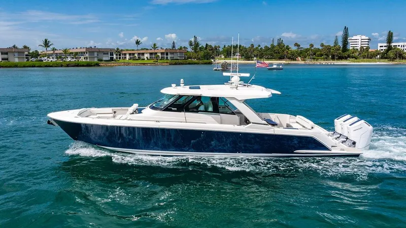 Slide: The Image of 2025 Tiara Yachts 48 LS cruising on blue water near a tropical shoreline. - 5