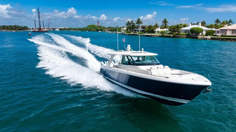 Slide: The Image of 2025 Tiara Yachts 48 LS cruising on blue water under a clear sky. - 7