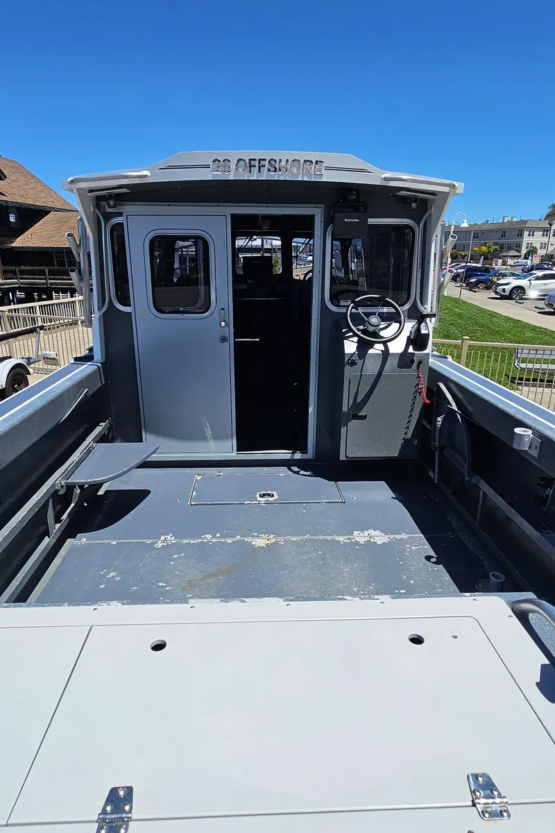 Slide: The Image of 2015 Duckworth 26’ Offshore boat with spacious deck and cabin, docked under clear blue sky. - 8