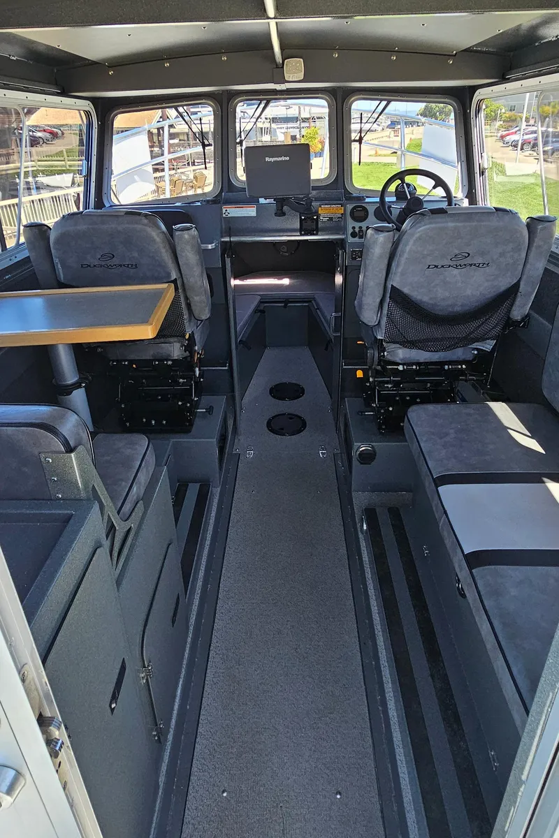 Slide: The Image of Interior of a 2015 Duckworth 26’ Offshore boat, featuring seating and navigation equipment. - 9