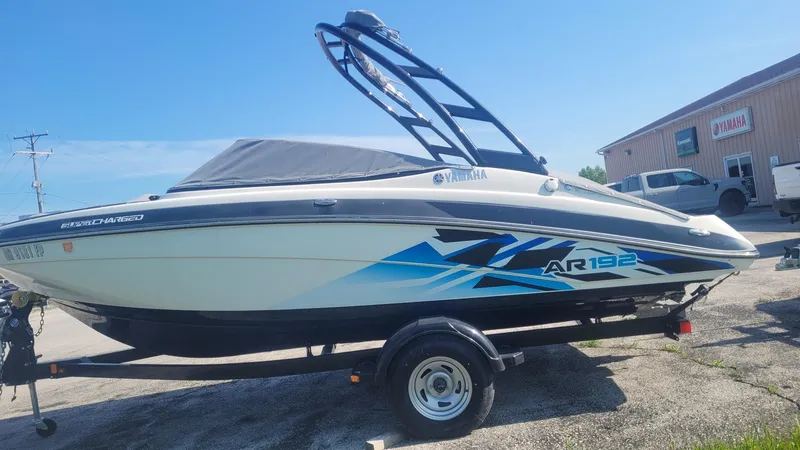 Slide: The Image of 2016 Yamaha AR192 boat on trailer, parked outdoors, with blue and black graphics. - 3