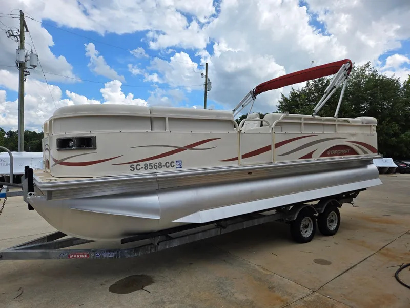 Slide: The Image of 2008 Starcraft Elite 226 RE CR pontoon boat on trailer, under a partly cloudy sky. - 1