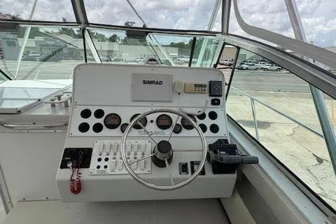 Slide: The Image of 1997 Stamas 310 Express boat helm with steering wheel and navigation controls. - 11