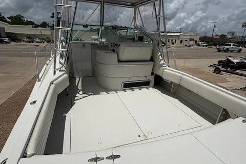 Slide: The Image of 1997 Stamas 310 Express boat with spacious deck and seating, docked under cloudy skies. - 12
