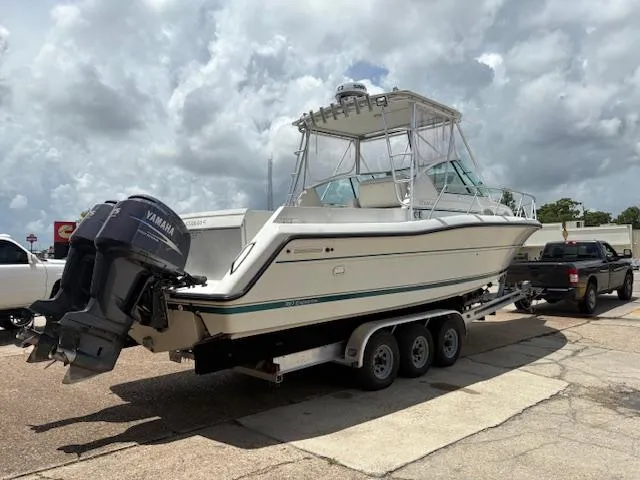 Slide: The Image of 1997 Stamas 310 Express boat on trailer, featuring Yamaha outboard motors, parked outdoors. - 2