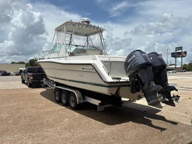 Slide: The Image of 1997 Stamas 310 Express boat on trailer with twin Yamaha outboard engines, parked outdoors. - 3