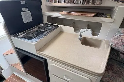 Slide: The Image of 1997 Stamas 310 Express boat kitchenette with stove, sink, and storage. - 8