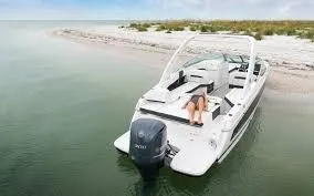 Slide: The Image of 2020 Regal 26 OBX boat docked near a sandy beach, featuring a sleek design. - 9
