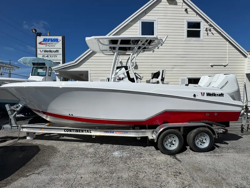 The Image of 2025 Wellcraft 242 Fisherman boat on trailer, displayed outdoors at dealership. - 1