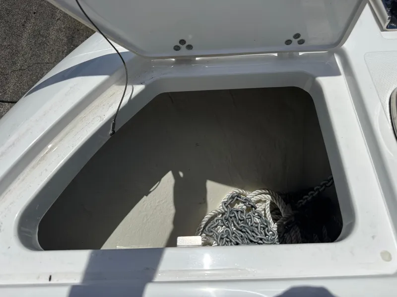 Slide: The Image of Open storage compartment on 2025 Wellcraft 242 Fisherman boat with rope and chain inside. - 23