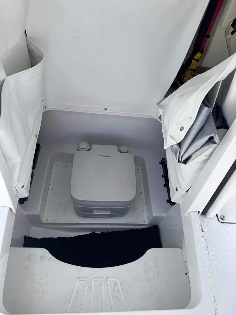 Slide: The Image of 2025 Wellcraft 242 Fisherman boat interior with portable toilet setup. - 27
