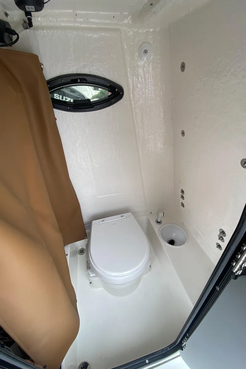 Slide: The Image of Interior of 2025 Sea Pro 225 Sandbar boat with compact bathroom amenities. - 13
