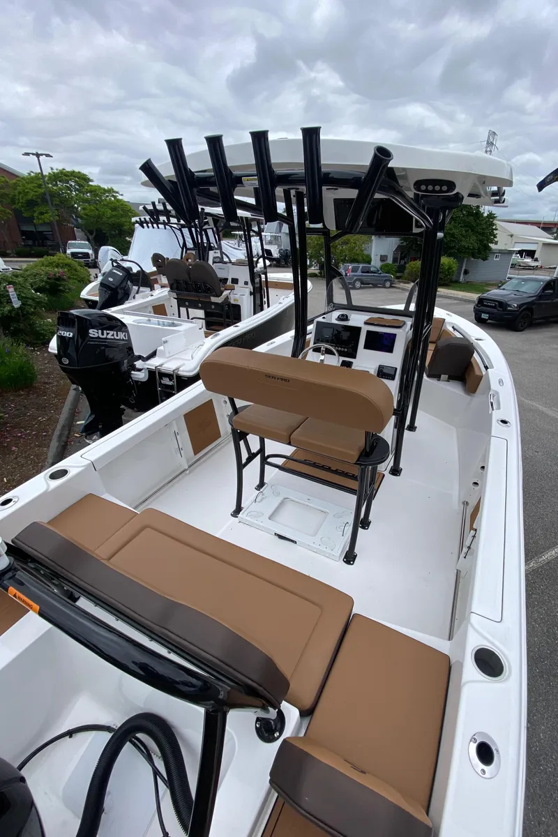 Slide: The Image of 2025 Sea Pro 225 Sandbar boat with brown seating and multiple rod holders. - 2