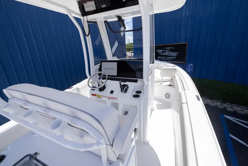 Slide: The Image of 2026 Sea Hunt Ultra 235 SE boat interior with Garmin navigation system, white seating, and steering wheel. - 12