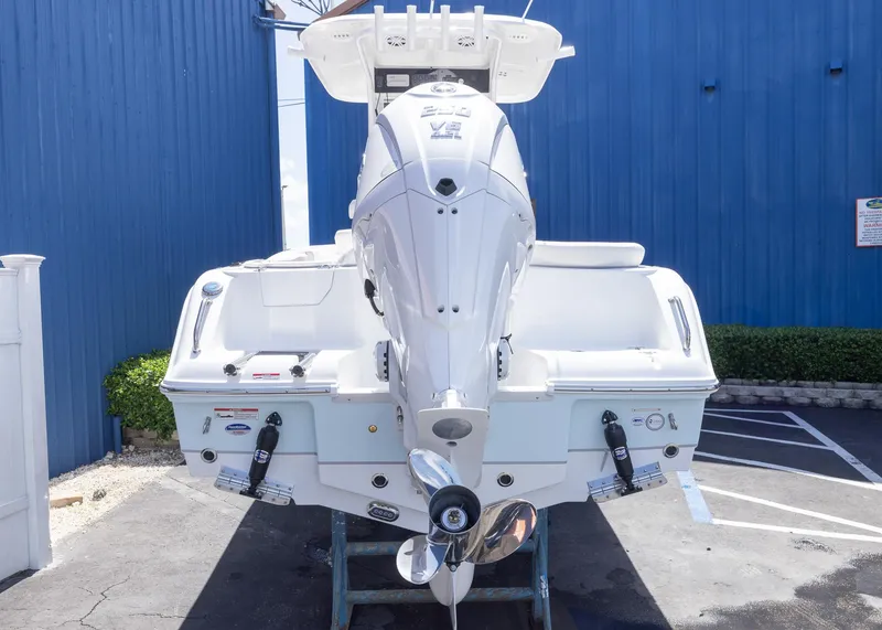 Slide: The Image of 2026 Sea Hunt Ultra 235 SE boat with powerful outboard motor, parked outdoors. - 19