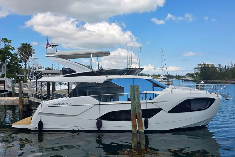 Slide: The Image of Luxury Absolute 47 Fly yacht docked at marina, 2021 model, under clear blue sky. - 0