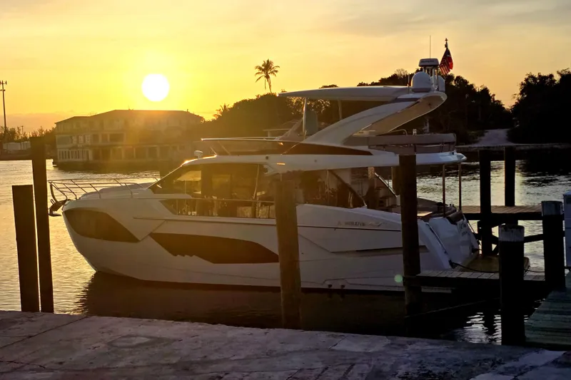 Slide: The Image of 2021 Absolute 47 Fly yacht docked at sunset, with serene waterfront view. - 4