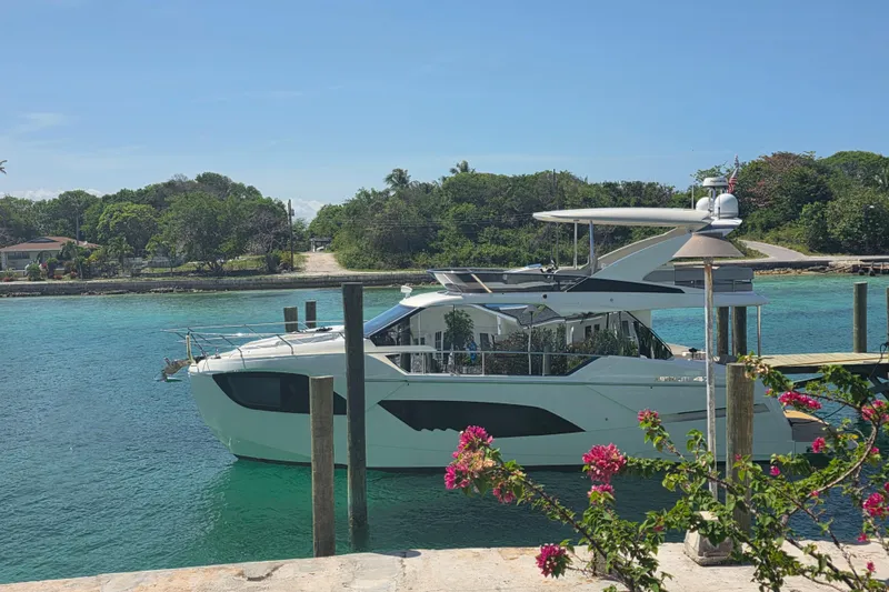 Slide: The Image of Luxury Absolute 47 Fly yacht docked in clear turquoise water, surrounded by lush greenery. - 5
