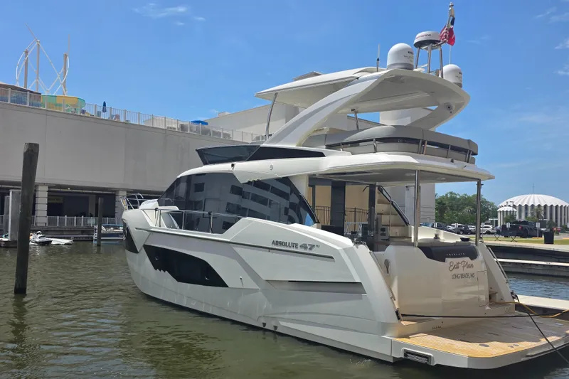 Slide: The Image of Luxury 2021 Absolute 47 Fly yacht docked at marina under clear blue sky. - 7