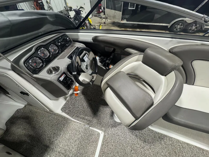 Slide: The Image of 2011 Yamaha Boats 242 Limited cockpit with steering wheel and gauges, featuring gray and white seating. - 10