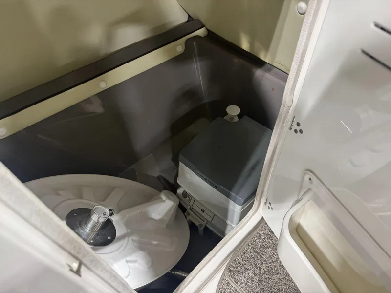 Slide: The Image of Interior storage compartment of 2011 Yamaha Boats 242 Limited, featuring a portable toilet. - 11