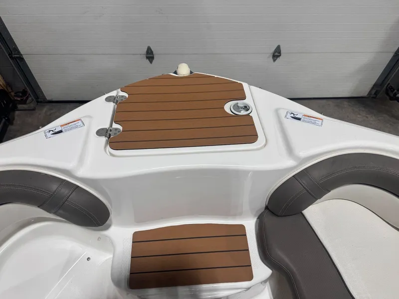 Slide: The Image of 2011 Yamaha Boats 242 Limited bow seating with brown decking and white upholstery. - 16