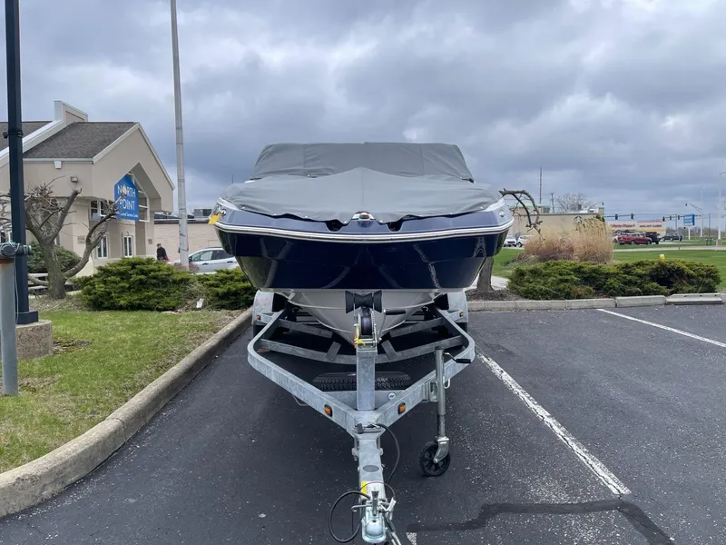 Slide: The Image of 2011 Yamaha Boats 242 Limited on trailer, covered, in parking lot. - 2
