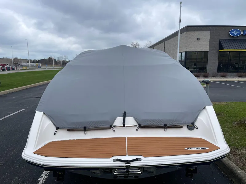 Slide: The Image of 2011 Yamaha Boats 242 Limited covered, parked outside dealership on cloudy day. - 5