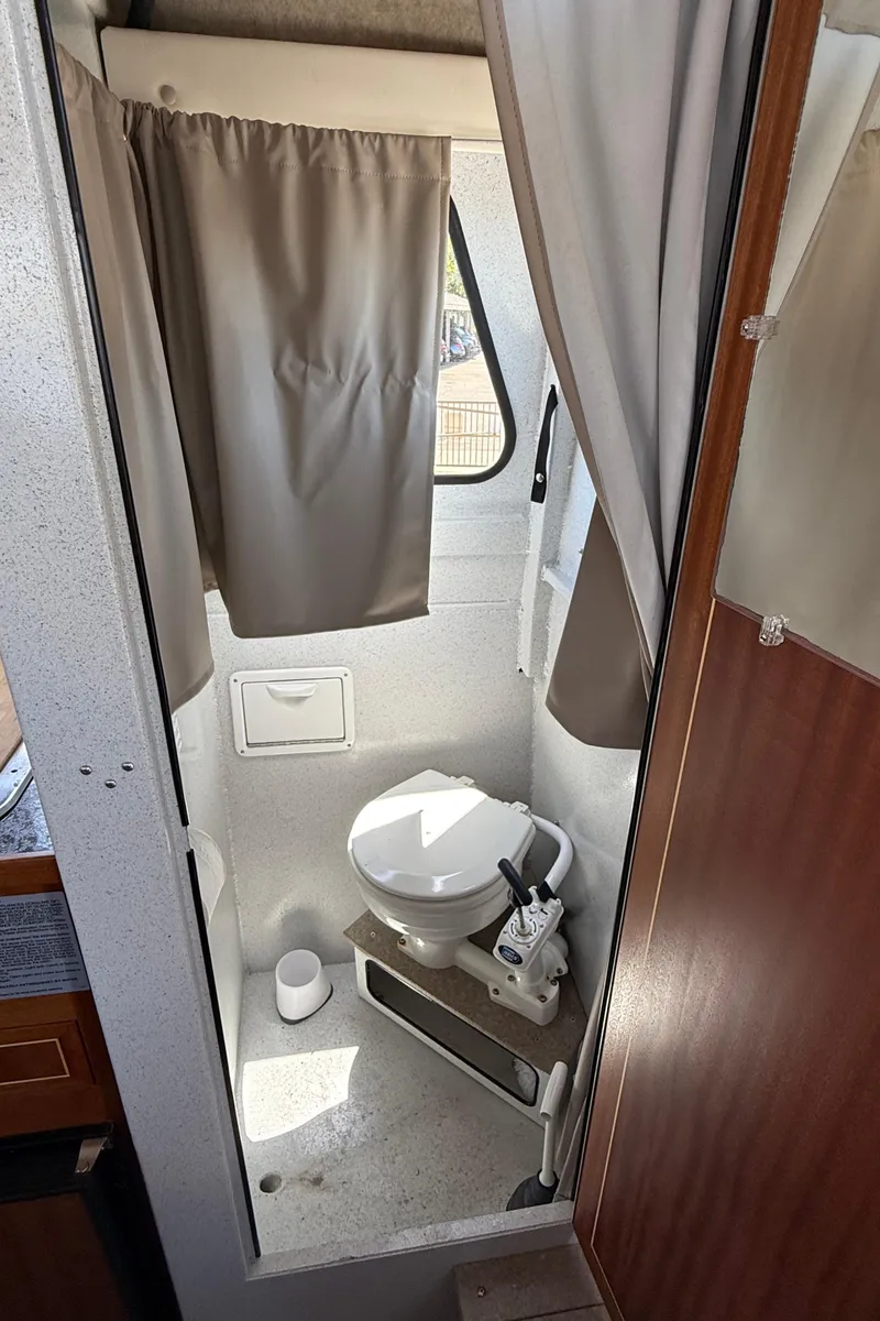 Slide: The Image of Compact bathroom in 2016 KingFisher 3025 Destination boat with toilet and curtain. - 11