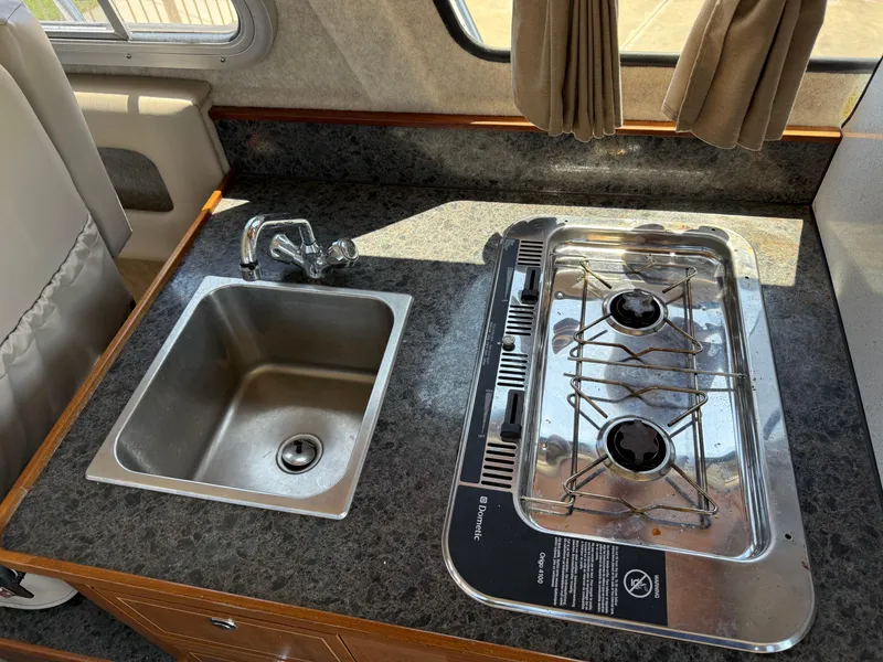 Slide: The Image of Compact kitchen area in a 2016 KingFisher 3025 Destination boat with sink and stove. - 12