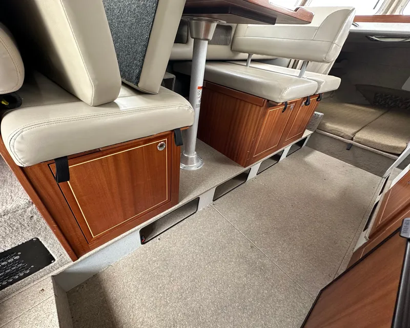Slide: The Image of Interior of 2016 KingFisher 3025 Destination boat with cushioned seating and wooden storage cabinets. - 19