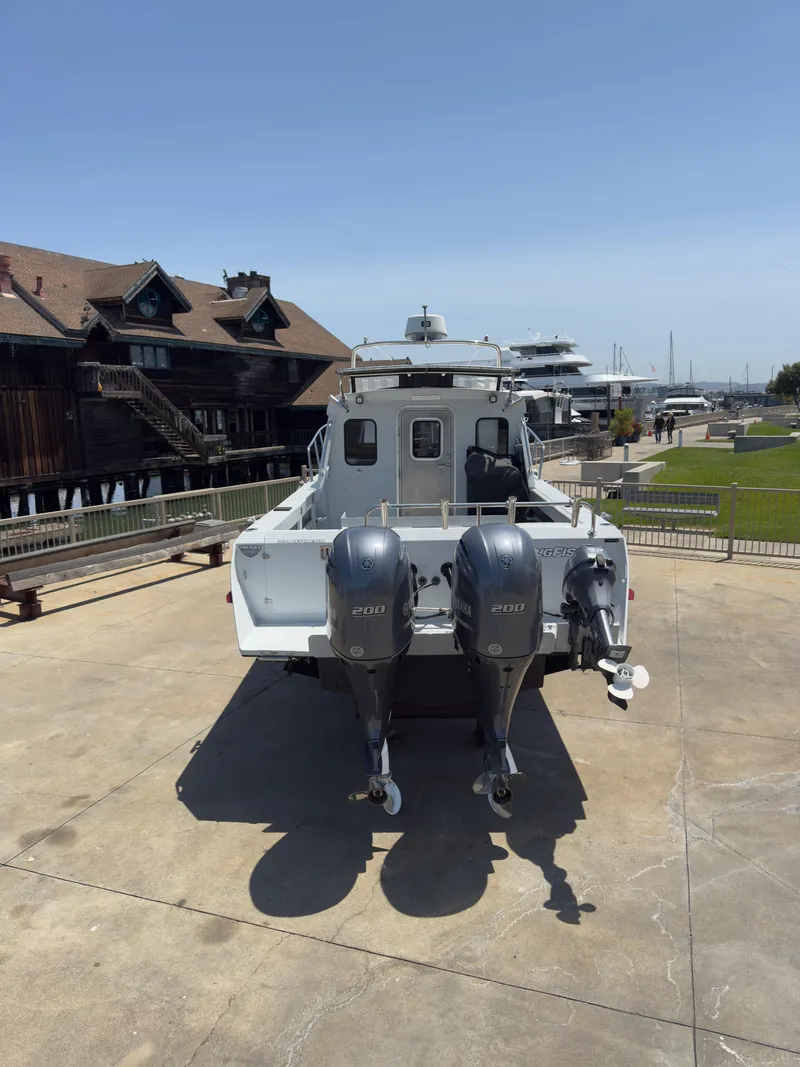 Slide: The Image of 2016 KingFisher 3025 Destination boat with dual engines, docked near waterfront buildings. - 21