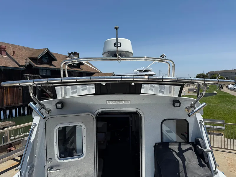 Slide: The Image of 2016 KingFisher 3025 Destination boat docked near wooden building and grassy area. - 22