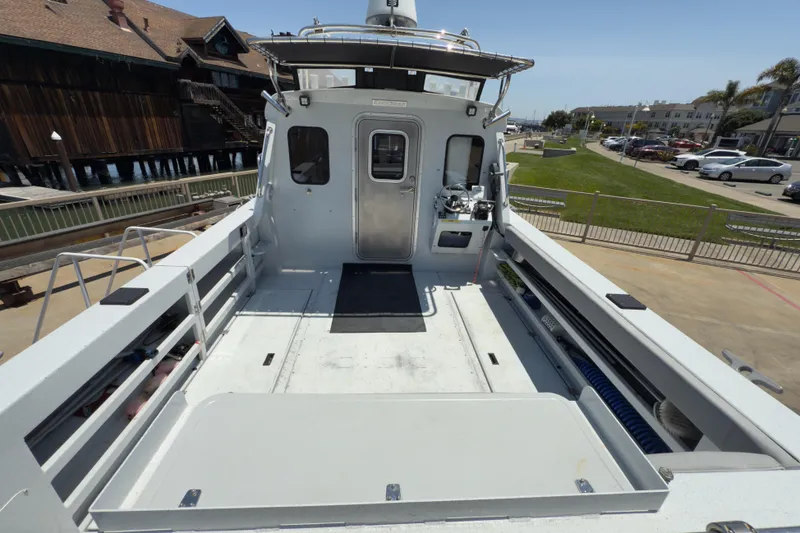 Slide: The Image of 2016 KingFisher 3025 Destination boat docked, showcasing spacious deck and cabin entrance. - 24