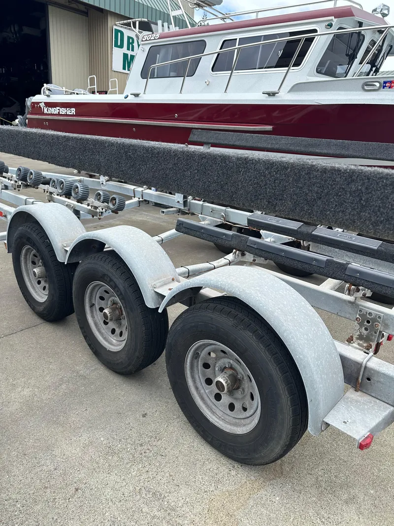 Slide: The Image of 2016 KingFisher 3025 Destination boat on a triple-axle trailer at a marina. - 35