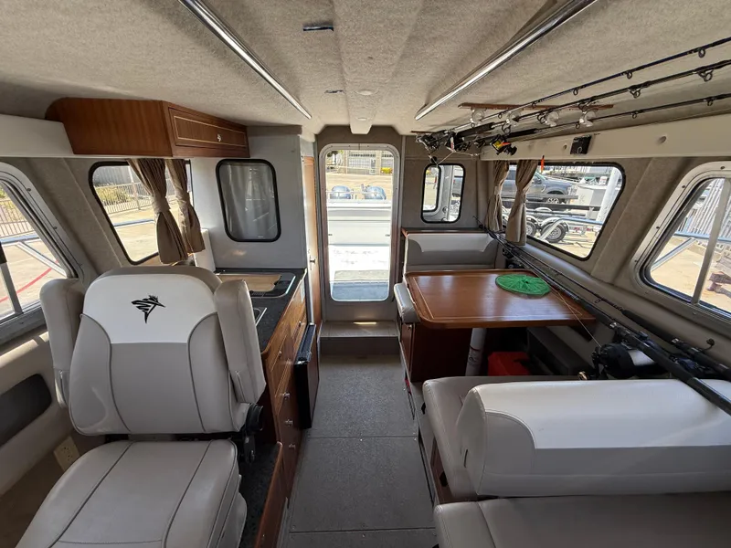 Slide: The Image of Interior of 2016 KingFisher 3025 Destination boat with seating, table, and fishing rods. - 7