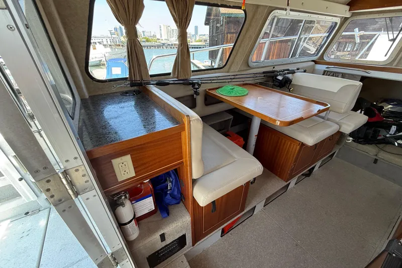 Slide: The Image of Interior of 2016 KingFisher 3025 Destination boat with seating and table, dock view outside. - 8