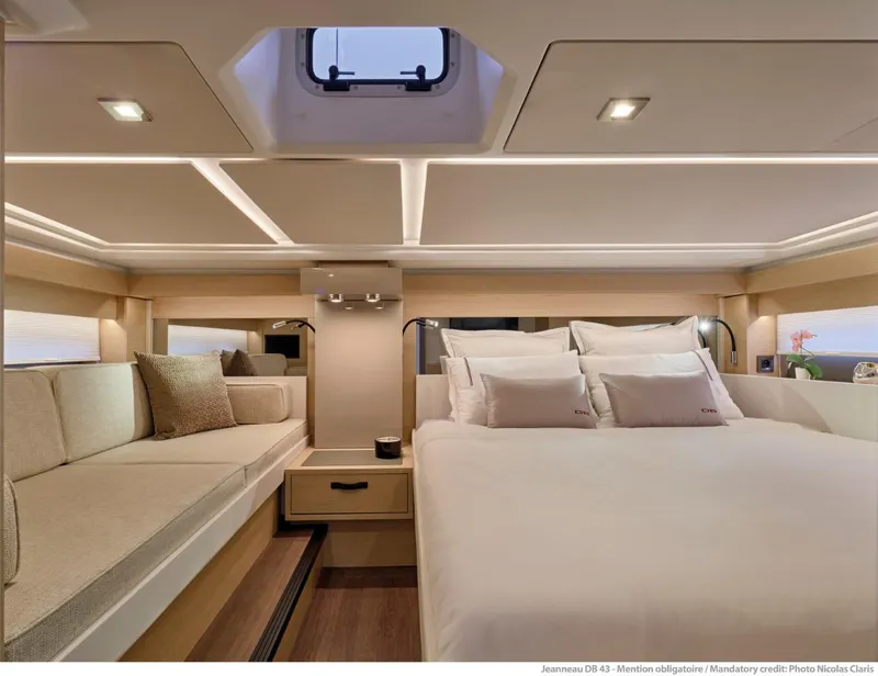 Slide: The Image of Luxurious interior of 2025 Jeanneau DB 43 yacht with elegant bedding and seating. - 12