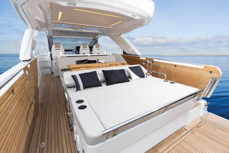 Slide: The Image of 2025 Jeanneau DB 43 yacht with luxurious deck and seating, overlooking serene ocean waters. - 9