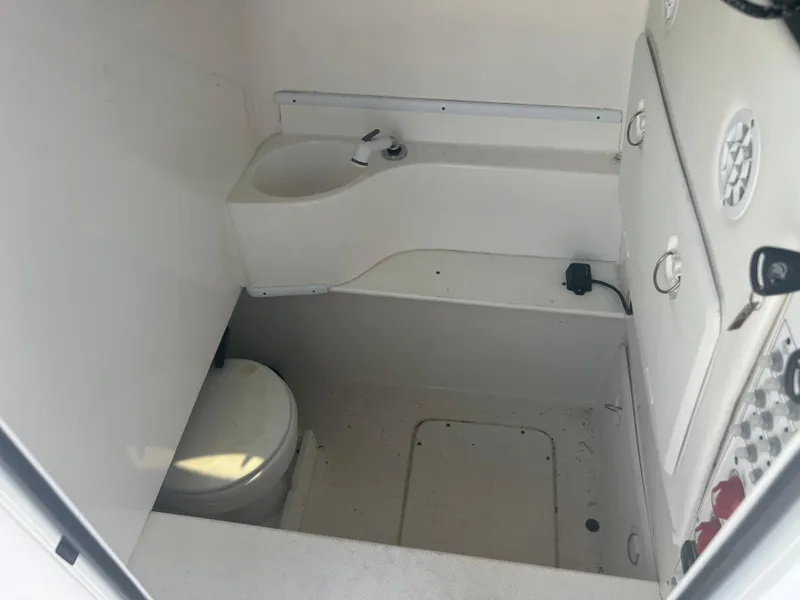 Slide: The Image of Interior of 2021 Contender 32 ST boat featuring compact bathroom with toilet and sink. - 23