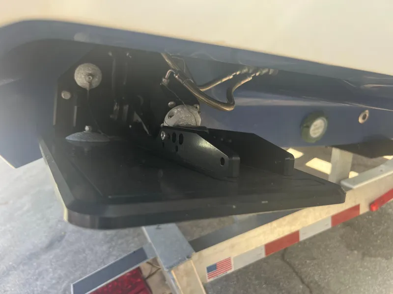 Slide: The Image of Close-up of a 2021 Contender 32 ST boat's trim tab mechanism on a trailer. - 26