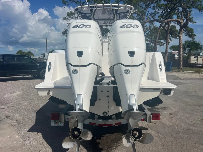 Slide: The Image of 2021 Contender 32 ST boat with twin 400 horsepower outboard engines, parked outdoors. - 6