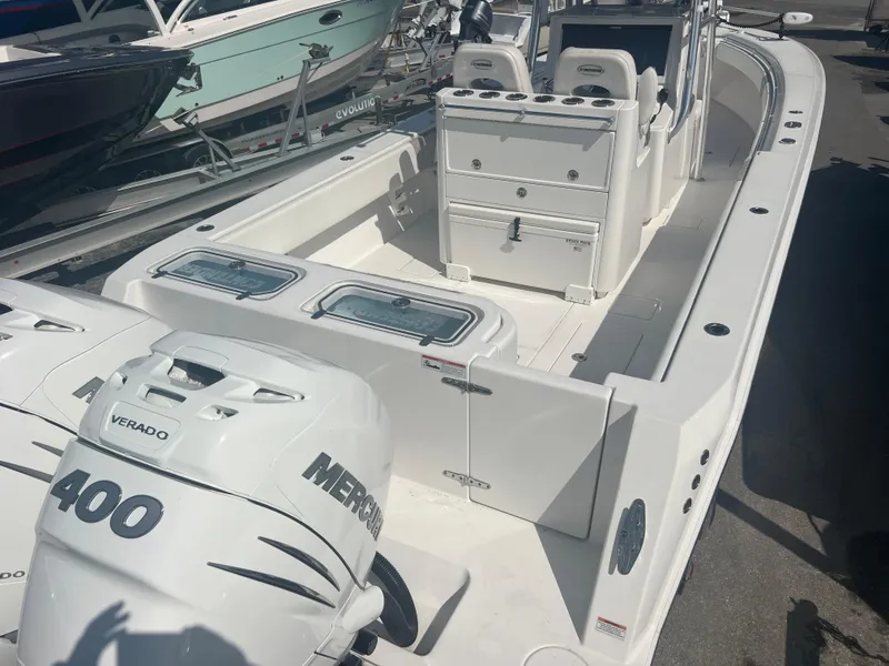 Slide: The Image of 2021 Contender 32 ST boat with dual Mercury Verado 400 engines, docked in a marina. - 7