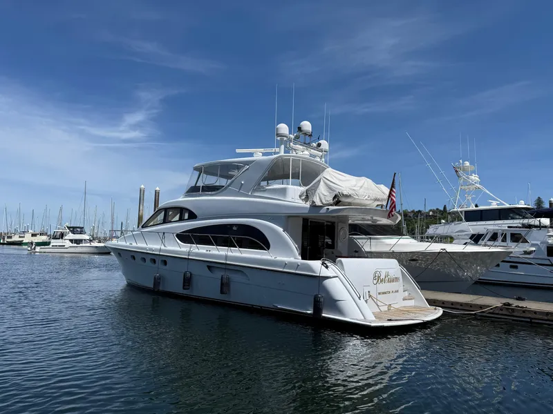Slide: The Image of 2001 Hatteras 63 Cockpit Motor Yacht docked in a marina under clear blue skies. - 1