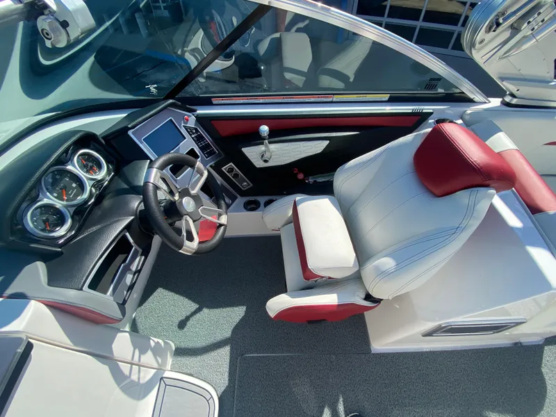 Slide: The Image of 2020 MasterCraft X26 boat cockpit with steering wheel, gauges, and white-red seating. - 27