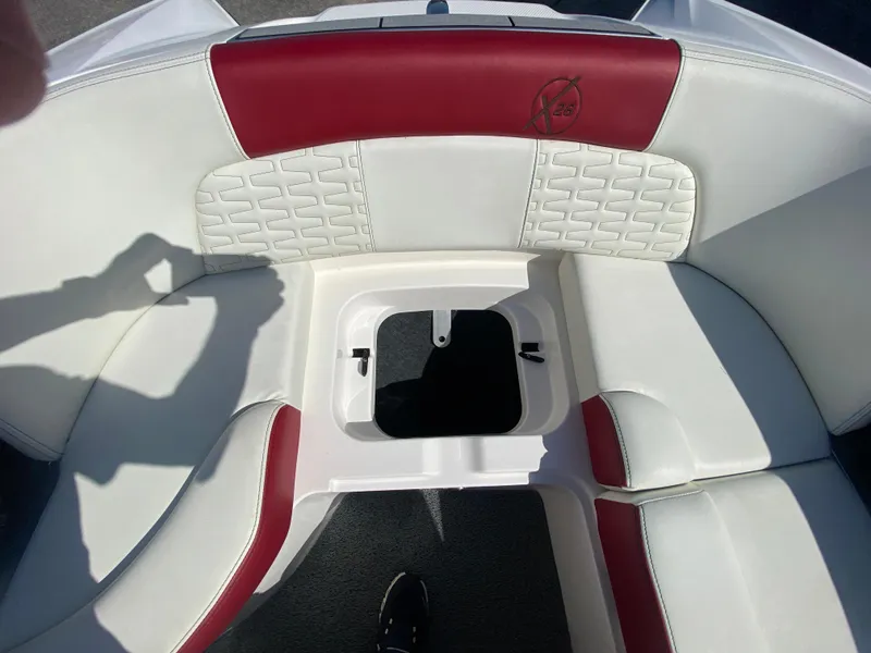 Slide: The Image of 2020 MasterCraft X26 boat interior with white and red seating, open storage compartment. - 32